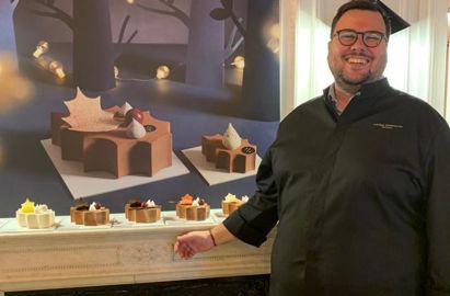 Photo Charly Marcolini avec DR CSM et légende : Charly Bourbon-Villalba, Directeur retail Europe pour Pierre Marcolini, pose devant la bûche 2022 signée Pierre Marcolini 